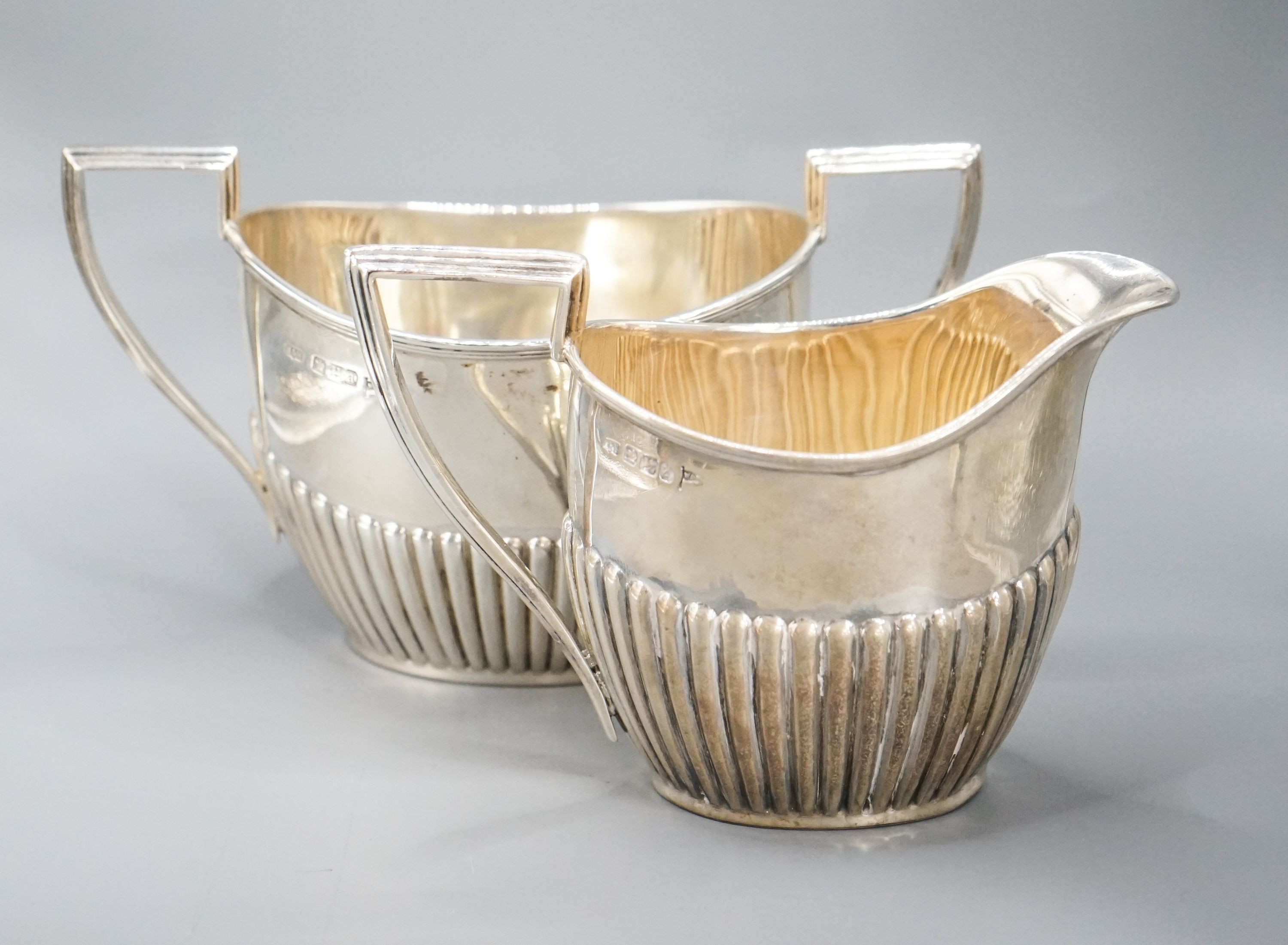 A late Victorian fluted silver cream jug and matching sugar bowl, by Walker & Hall, Sheffield, 1892/3, 13oz.